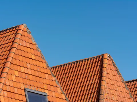 Gables with orange clay tiles against a blue sky