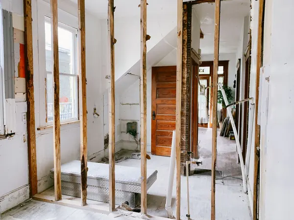 Room in an older house being renovated, with the walls opened up to the studs