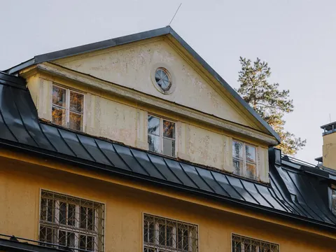 Eldre gul villa med svart falset platetak