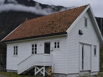 Hvitt trehus med tak av rød takstein